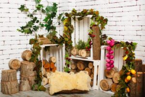 Cozy display of wooden logs and crates adorned with vibrant foliage.
