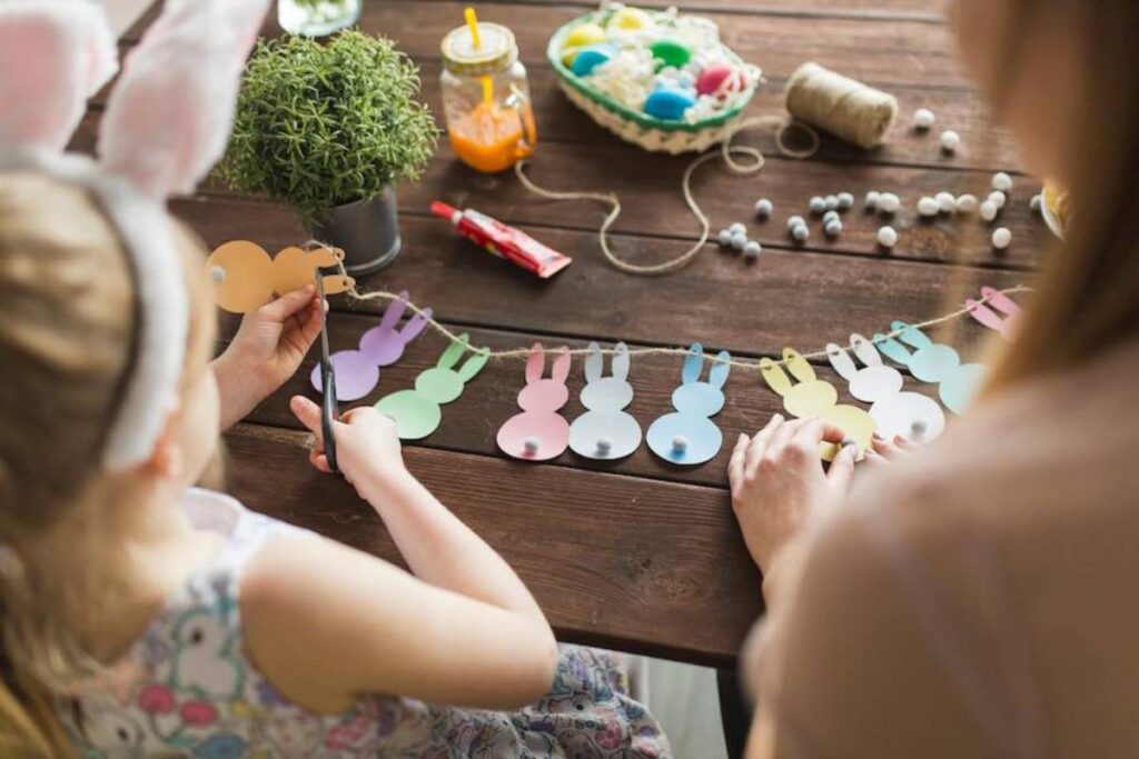A child with bunny ears cuts colorful paper.